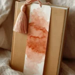 DIY Watercolour Bookmarks with tassel accent hanging from closed book